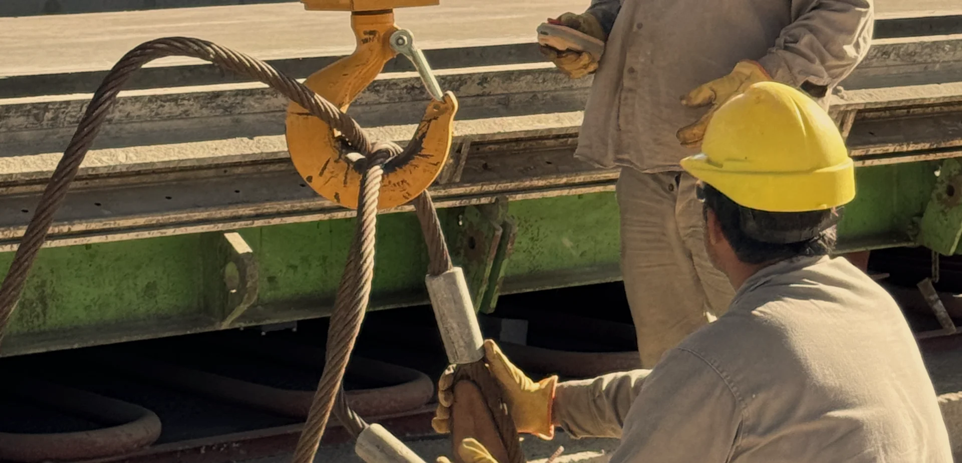Detalle técnico de herrajes y cables de acero para elevación de paneles pesados.