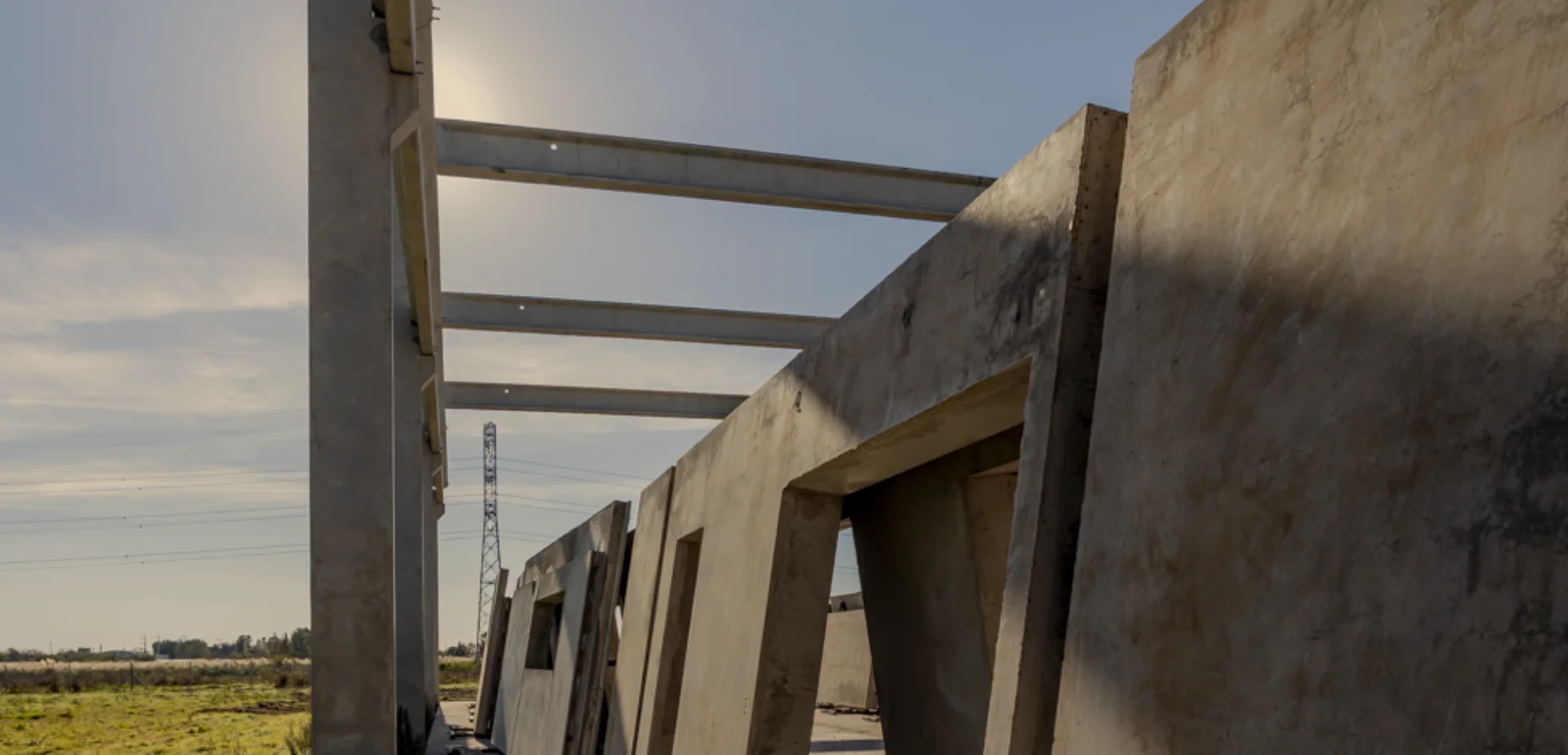 Estructura de vigas y columnas de concreto prefabricado en obra industrial.